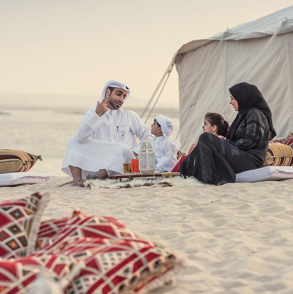 Family in traditional Islamic dress at a Bedouin camp in the desert