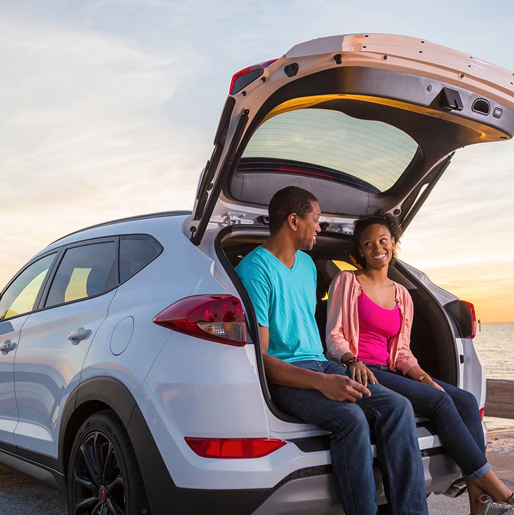 couple seated in back of Alamo rental